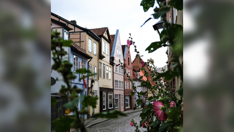 Das Bild zeigt eine Altstadtgasse mit Blumen