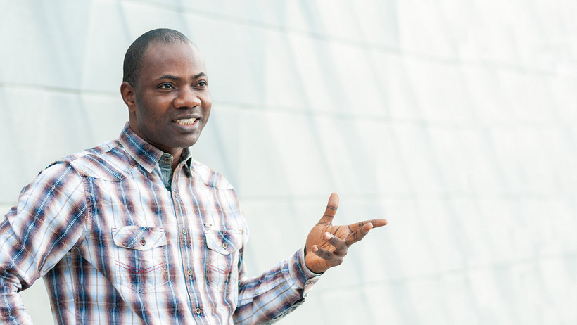 Ezekiel Olajimbiti in front of the Libeskind building