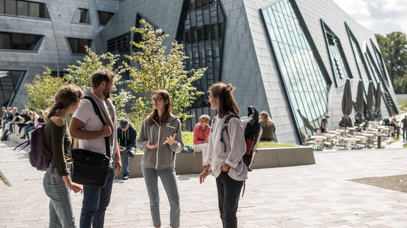 Group of students having a talk in front of the central building