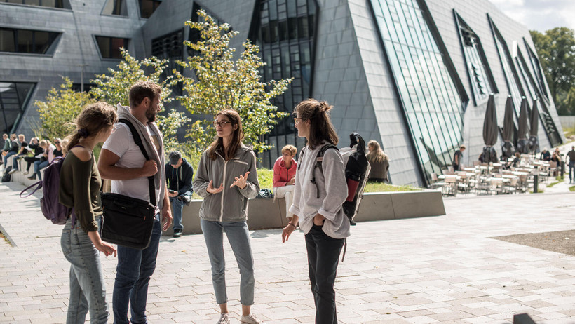 Studierende im Gespräch vor dem Zentralgebäude 