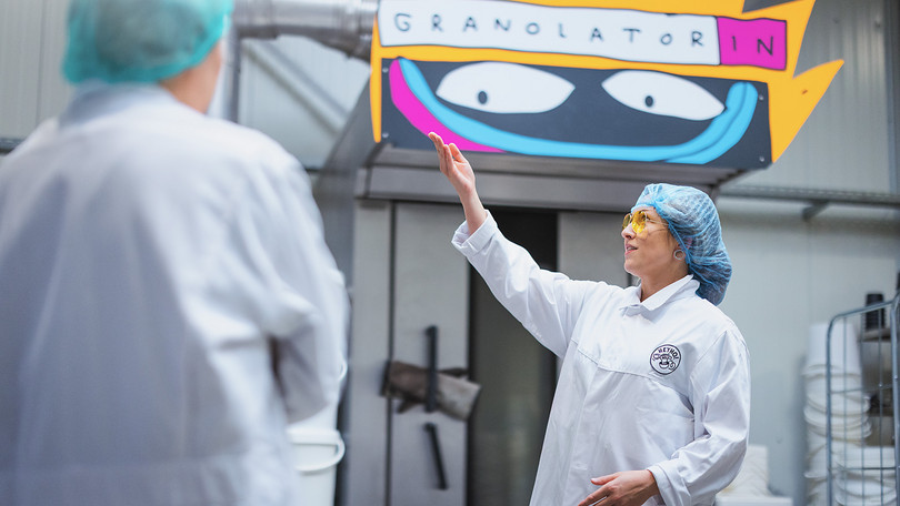 Eine Mitarbeiterin erklärt die Produktion bei Heyho.