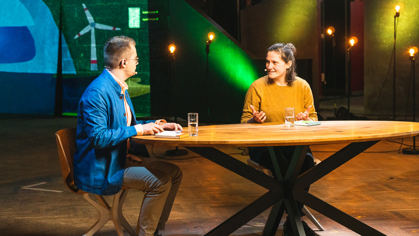 Juli Biemann sitzt mit Cornelius Gesing an einem Tisch.