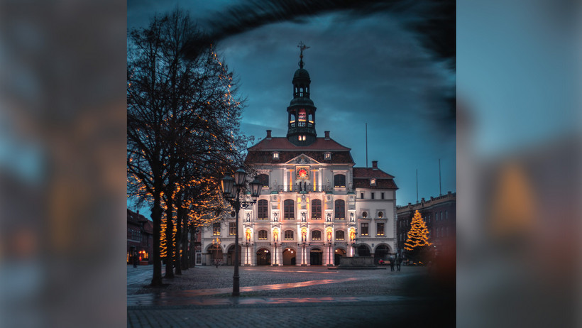 Das Bild zeigt das Lüneburger Rathaus im Dunkeln, der Platz davor ist menschenleer
