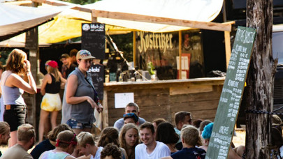 Bar, vor dem vielen Menschen im Kreis sitzen und sich unterhalten