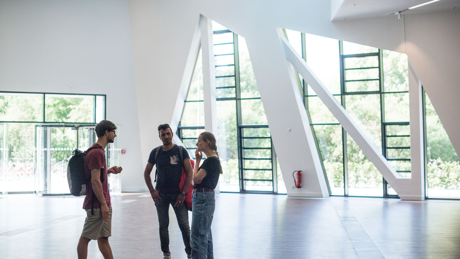 Studierende unterhalten sich im Foyer des Zentralgebäudes Talking students in the entrance hall of Leuphana's central building.