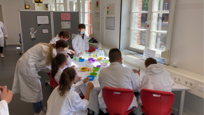 Das Foto zeigt Schüler*innen, die verschiedene Substanzen in der Lernwerkstatt "Es sprudelt und schäumt" untersuchen.