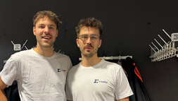 Die Gründer Finn Ripp und Niklas Ruge stehen vor einer Reihe Garderobenhaken