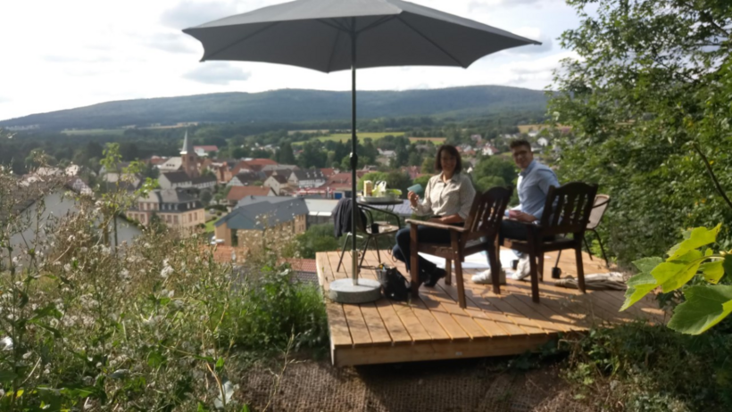 Menschen sitzen entspannt auf einer Terasse