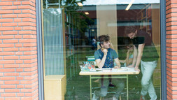 Zwei Studenten hinter dem Fenster