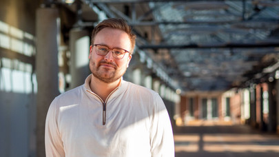 Portrait von Silas Kißmer, Student des Masterprogrammms Rechtswissenschaften, im Hörsaalgang der Leuphana Universität Lüneburg