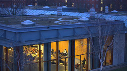 Außenansicht einer Podiumsdiskussion im Hörsaal bei Dämmerung