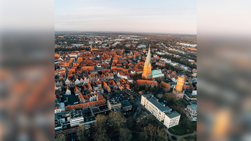 Das Bild zeigt den Platz Am Sande und die Johanniskirche im Abendlicht