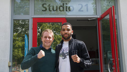 Boxmeister Jerry Alabi mit dem Leister des Universitätsportzentrums vor dem Studio 21