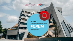 Ein zackiges Gebäude im Hintergrund, davor die Logos der Leuphana und der Social Entrepreneurship Allianz und die Beschriftung "Social Entrepreneurship Hamburg" und "2. März 2027".