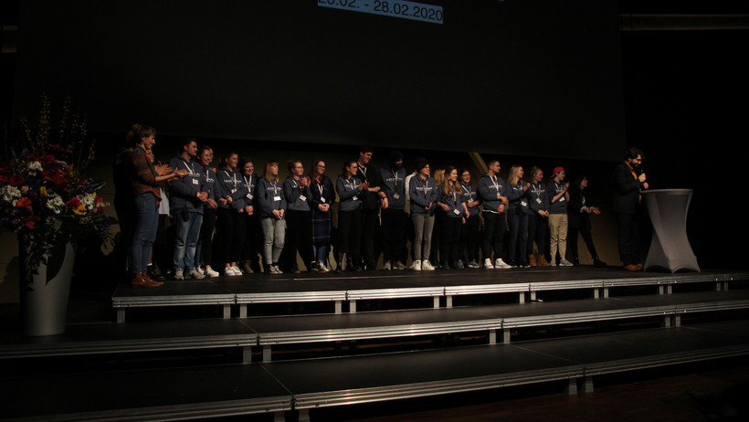 Sven Prien-Ribcke schließt die Veranstaltung mit einem großen Dank an die Leitungen der beteiligten Seminare, seine Kolleg*innen und die Theatergruppe der Eröffnungsveranstaltung. „Eigentlich ist mein Job überflüssig“, kommt er zum Schluss und ruft das Konferenzwochenteam auf die Bühne, das die letzten drei Tage überhaupt erst ermöglicht habe. Auch von uns heißt es nun: Bis zum nächsten Jahr!