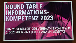 Ein großer Screen, auf dem die Veranstaltung Round Table Informationskompetenz 2023 angezeigt wird