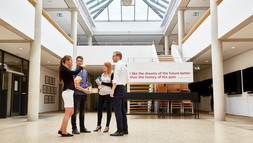 Studierende unterhalten sich im Foyer der Bibliothek