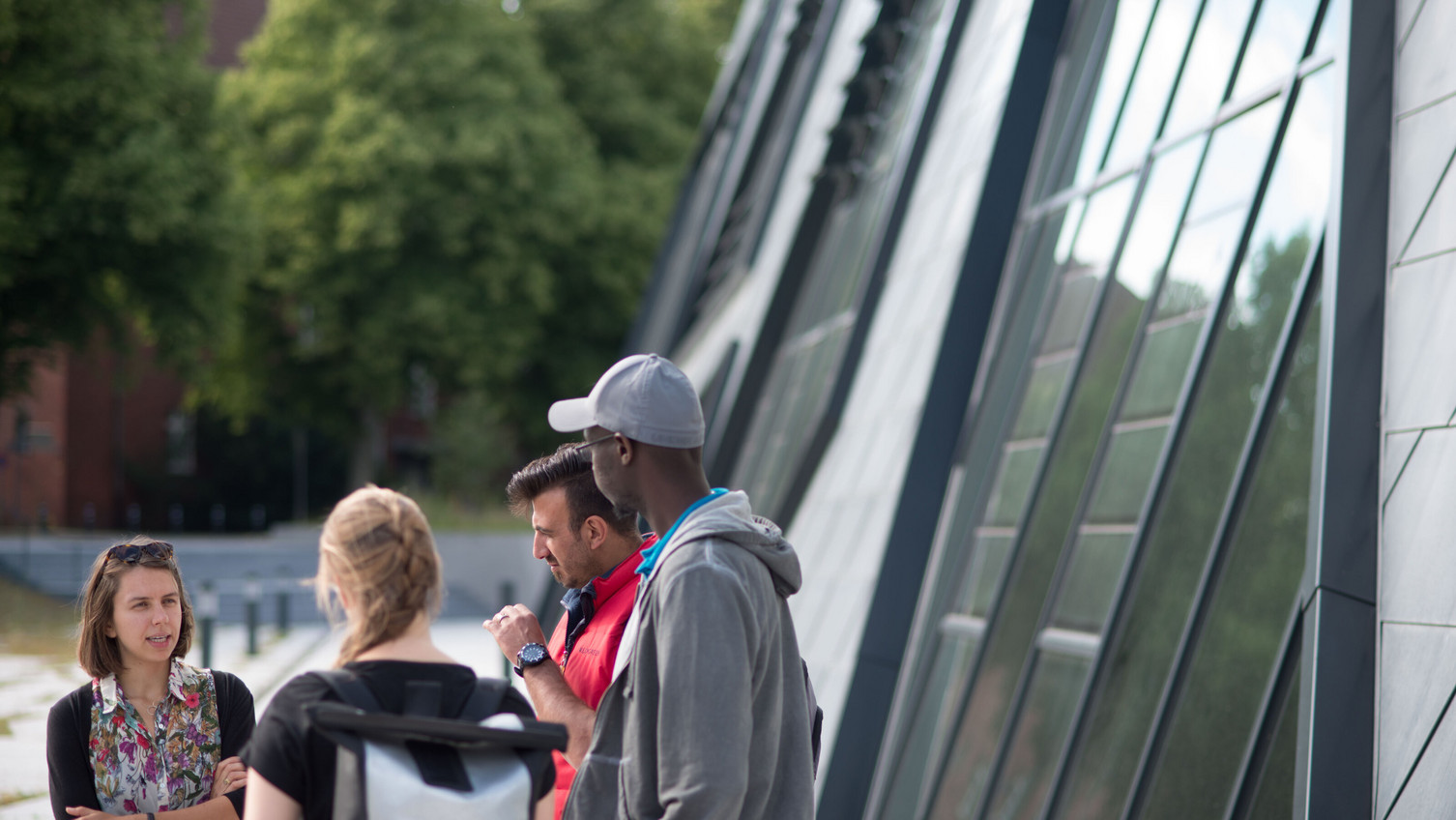 Studierende unterhalten sich vor dem Zentralgebäude
