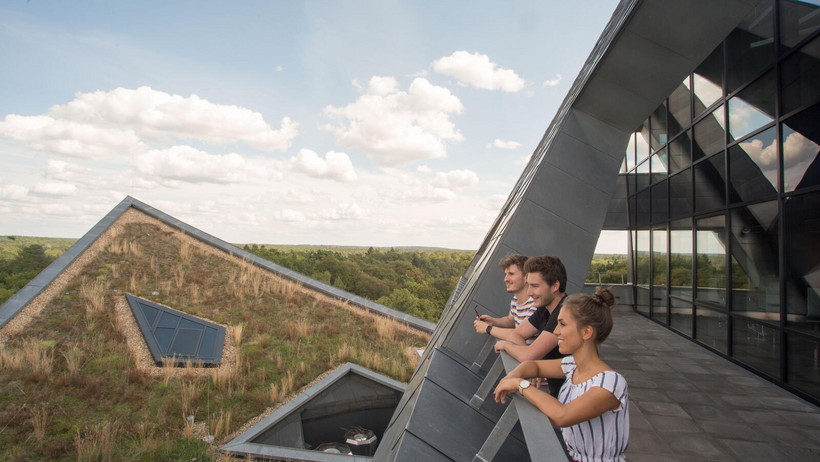 Studierende mit Blick auf Lüneburg von der Außengalerie des Zentralgebäudes