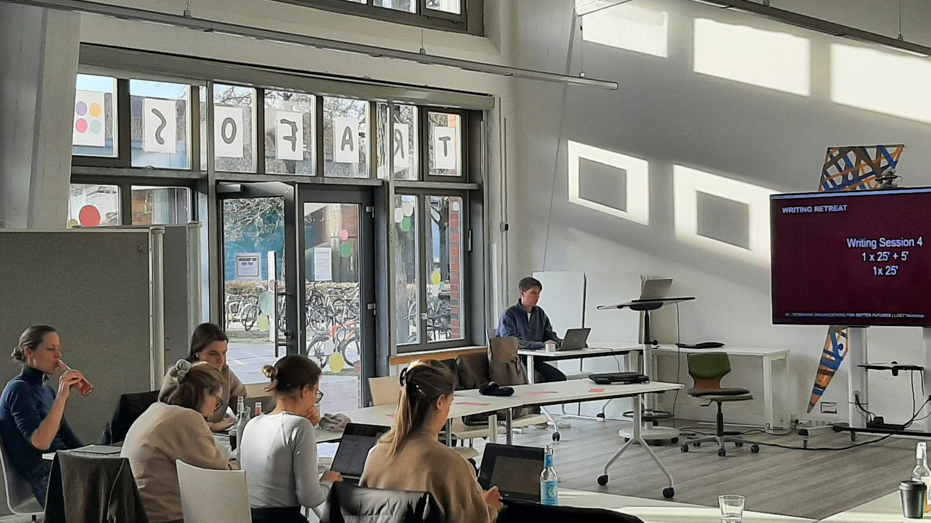 People sitting in a room together to work on writing projects.