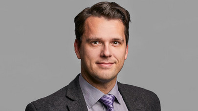 Portraitfoto von Prof. Dr. Patrick Velte in Anzug und Krawatte vor grauem Hintergrund